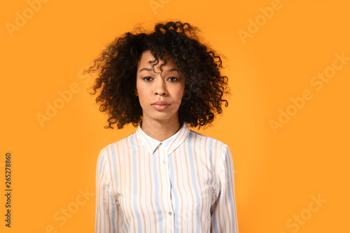 Young African-American woman on color background
