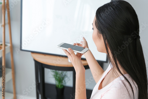 Young Asian woman with mobi...