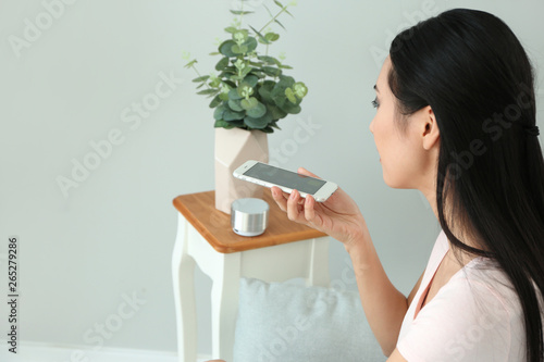 Young Asian woman with mobi...