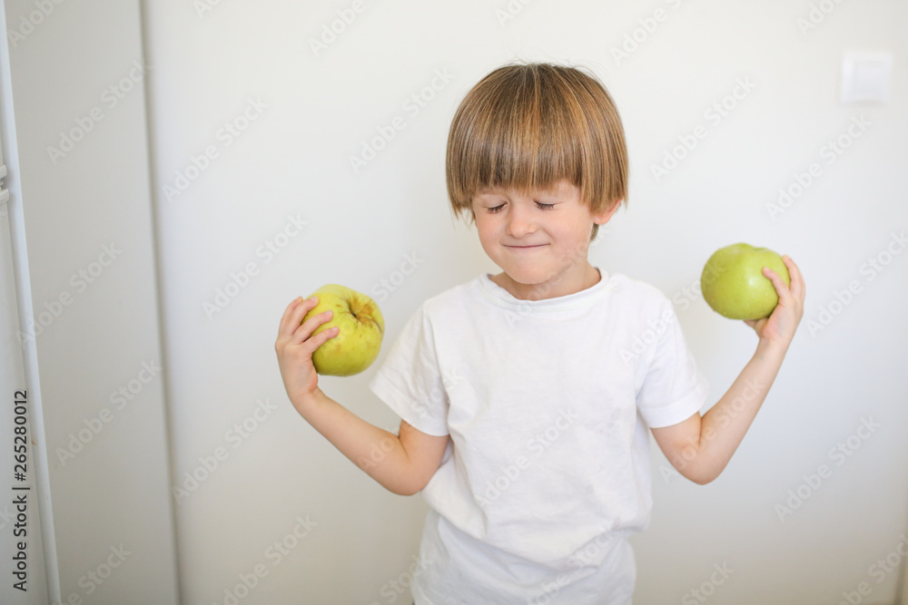 strong and healthy boy with an apple, kitchen strong and healthy boy with an apple, kitchen