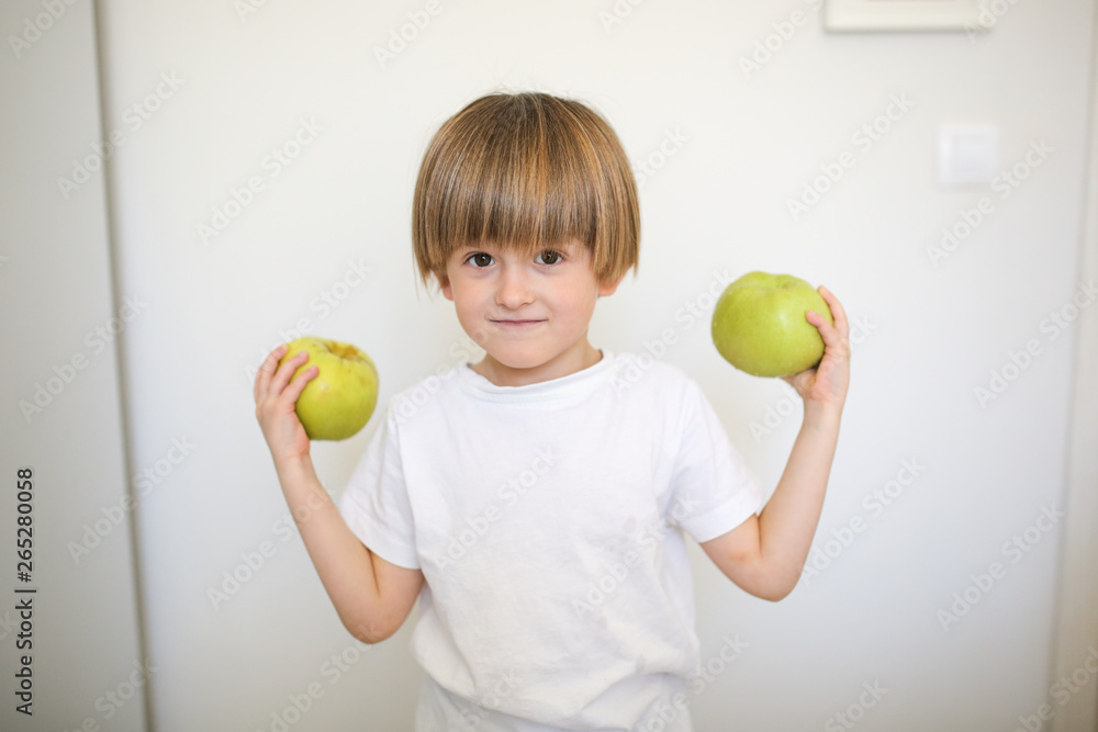 strong and healthy boy with an apple, kitchen strong and healthy boy with an apple, kitchen