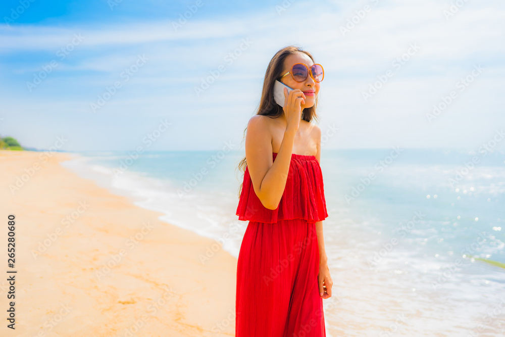 Portrait beautiful young asian woman using cellphone or mobile phone on the beach and sea Portrait beautiful young asian woman using cellphone or mobile phone on the beach and sea