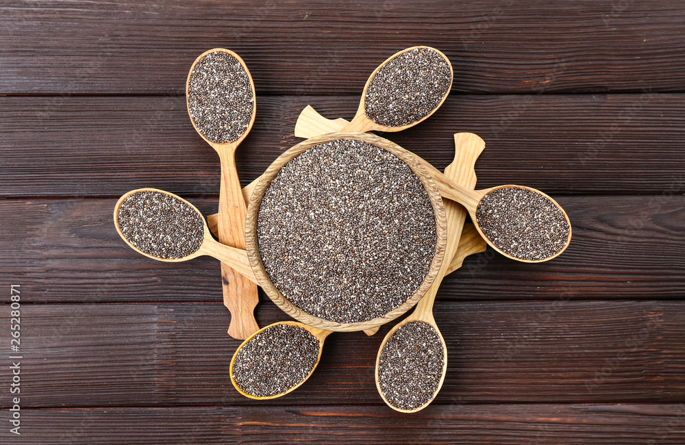 Bowl and spoons with chia seeds on wooden table Bowl and spoons with chia seeds on wooden table