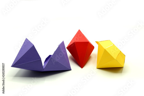Geometric shapes cut out of colored paper and photographed from above on white background. Geometry net of Octagonal Dipyramid. 2D shape that can be folded to form a 3D shape or a solid.