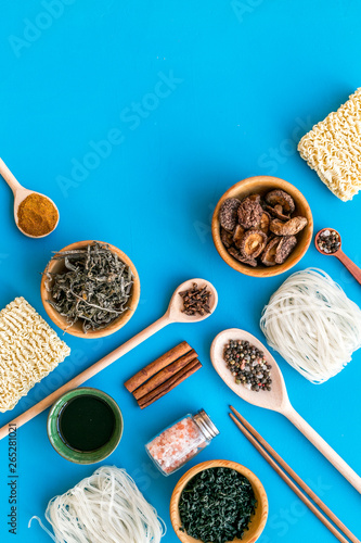 Chinese and Japanese food cooking with ginger, spices and noodles on blue background top view mock up photo