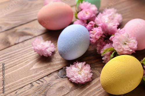 Beautiful Easter eggs with flowers on wooden background