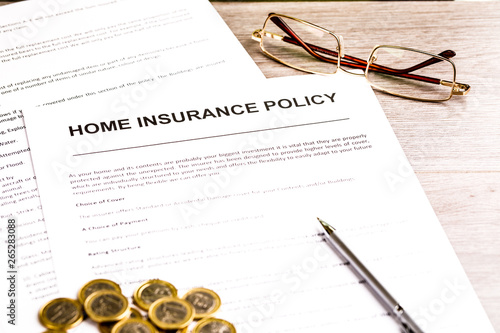 Home insurance policy. Glasses, documents, pen and coins on table. Business and insurance background concept
