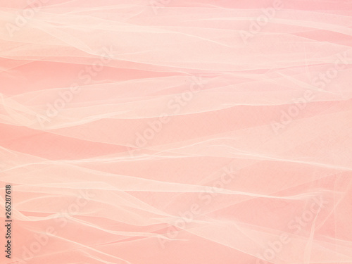 Lightweight fabric mesh lace on pink paper, texture of the fabric is beautifully draped background. Abstract soft chiffon veil backdrop. Bride concept