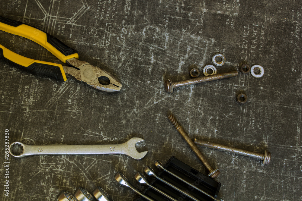 Tool set of pliers, wrenches, bolts and nuts on abstract grey surface Tool set of pliers, wrenches, bolts and nuts on abstract grey surface