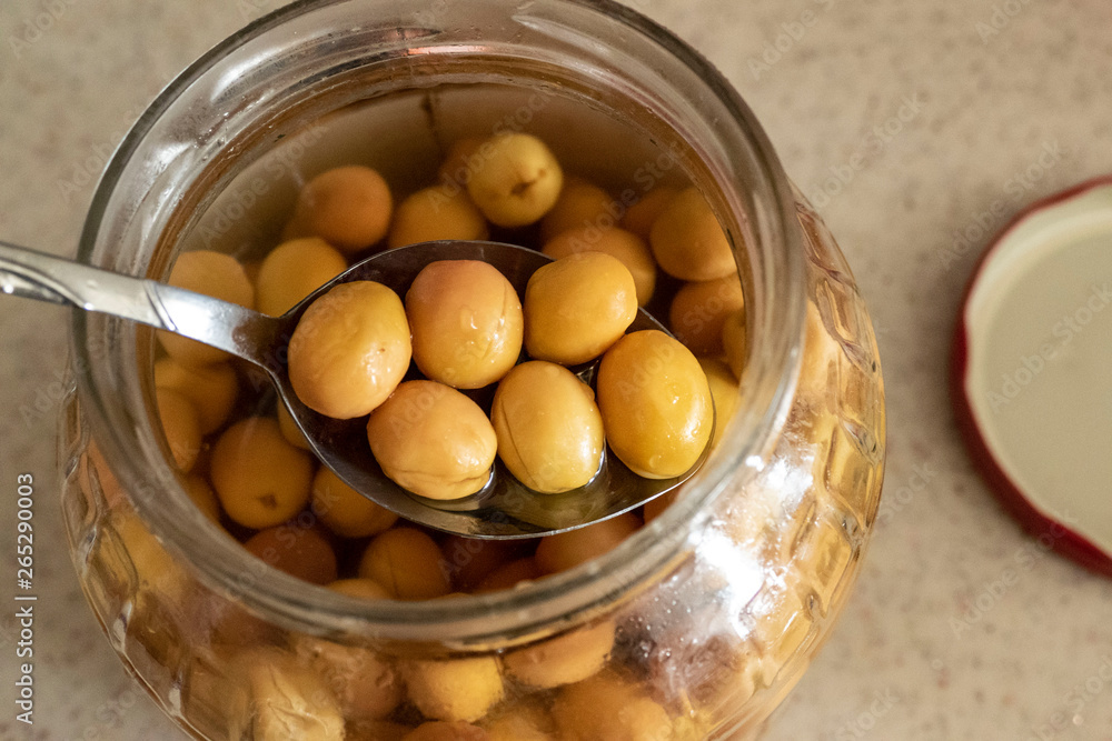 green scratched olives and spoon in jar, close-up, green scratched olives and spoon in jar, close-up,