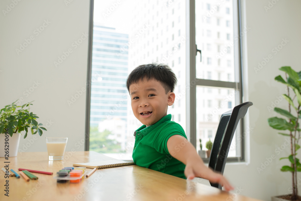 happy little boy laughing while studying and looking at camera happy little boy laughing while studying and looking at camera