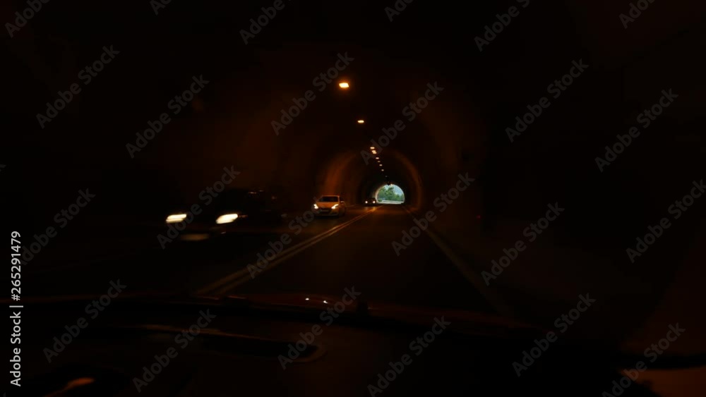 Car ride through dark tunnel, mountain road at Crete, POV camera look through windshield. Several vehicles move in opposite direction. Drive till exit from underground section Car ride through dark tunnel, mountain road at Crete, POV camera look through windshield. Several vehicles move in opposite direction. Drive till exit from underground section