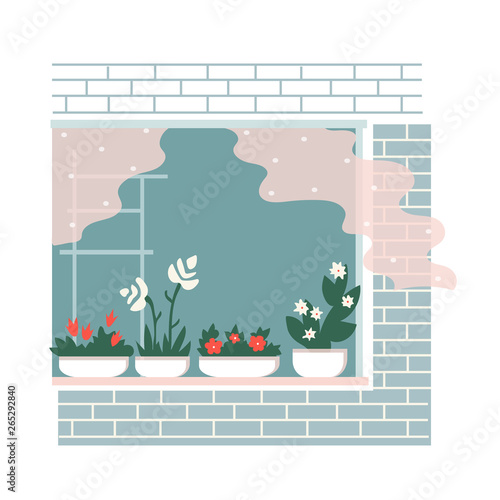 Cozy window in the brick wall. Flowers on a windowsill. 