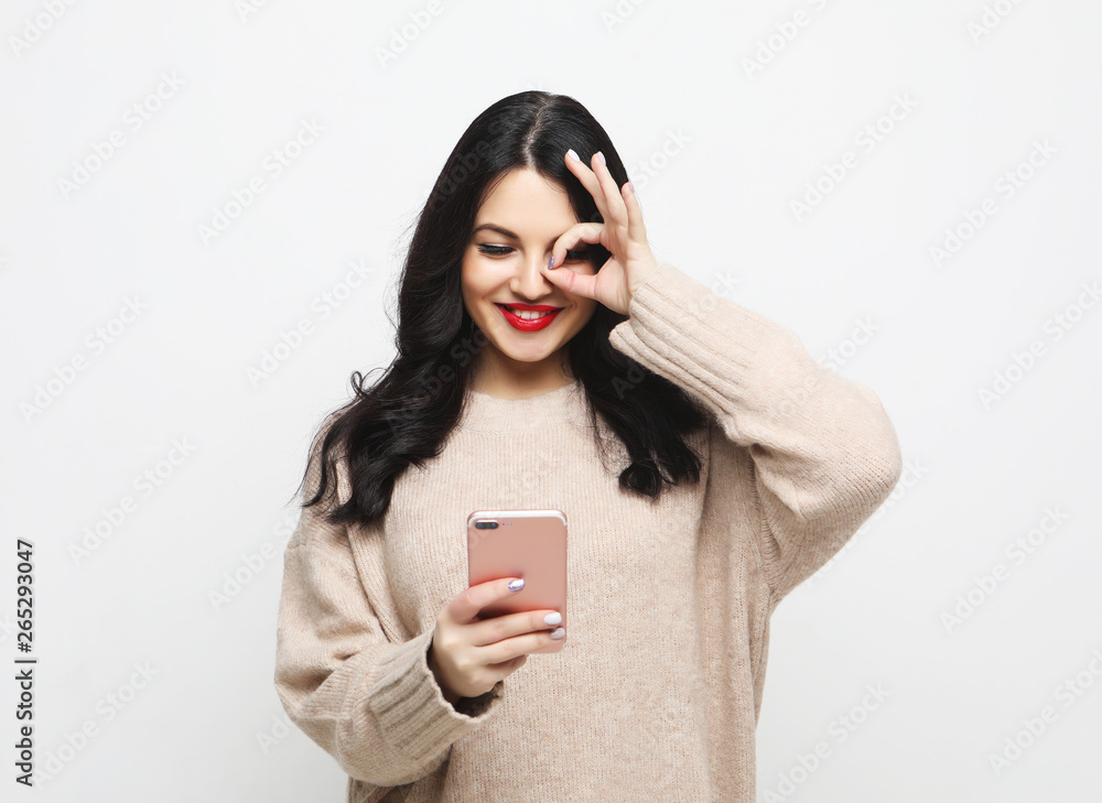 Naklejka premium Fashion curvy brunette girl taking photo makes self portrait on smartphone
