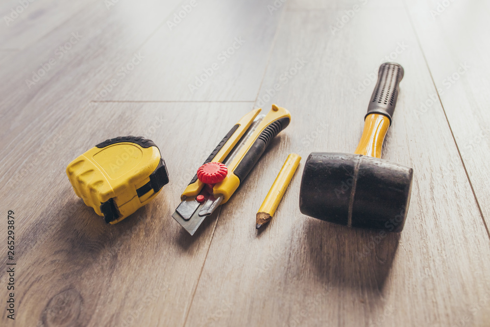 Tools for laying laminate - knife, tape measure, hammer and pencil Tools for laying laminate - knife, tape measure, hammer and pencil