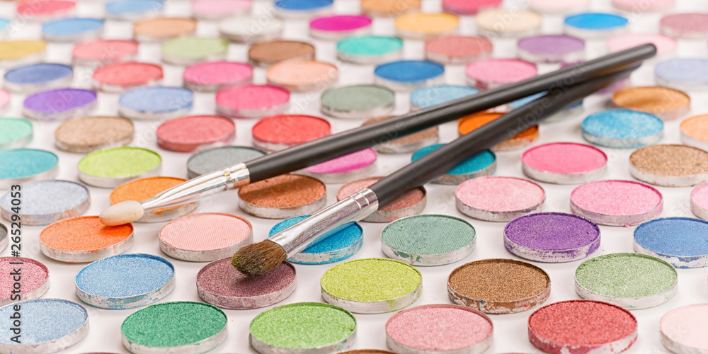 Two cosmetic brushes laying on colored eye shadows Two cosmetic brushes laying on colored eye shadows