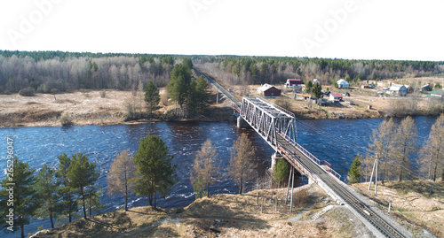 Aerial view on the rail bridge across the river in rural place in spring