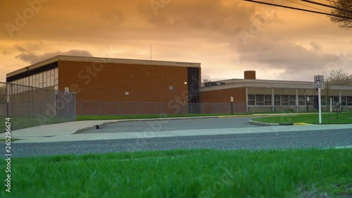 Wallpaper Mural Sunset evening school exterior establishing 4k video shot. DX elementary high education building street view lock down. Beautiful orange sky and clouds overhead. Torontodigital.ca