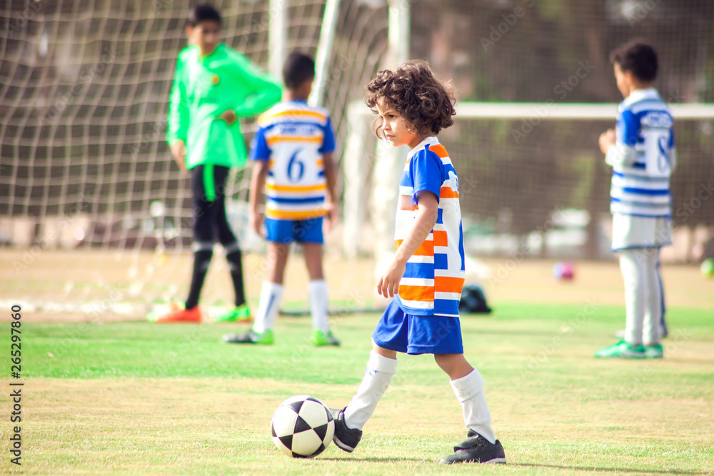 Little boy plays football outdoor. Children and lifestyle concept