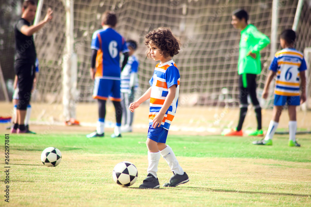Obraz premium Little boy plays football outdoor. Children and lifestyle concept
