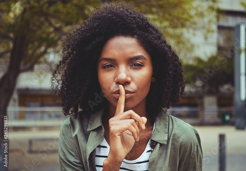 A young woman making silence gesture photo