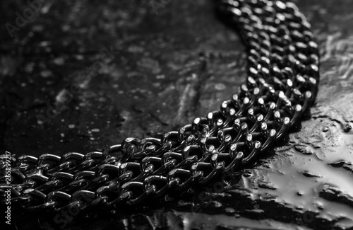 Shiny metal chains on stone background