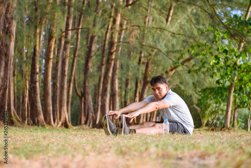 Asian man stretching body before running at the park and sunset time
