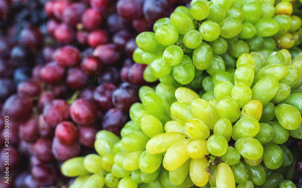 bunch of fresh green grapes and red-black grapes in a local market. healthy fruits
