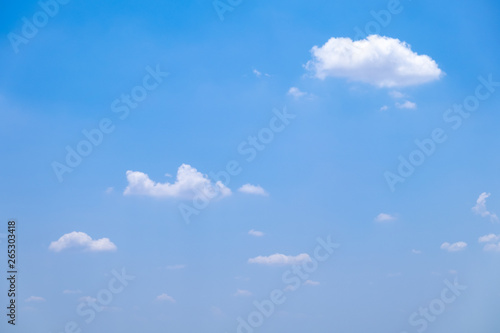 Fuffy clouds on bright blue sky background.