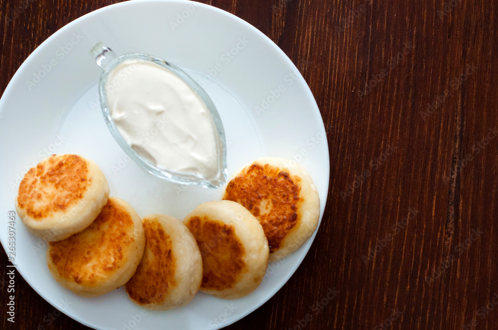 Fried cheese pancakes with sour cream , with space for text on the right. For cafe or restaurant menu design. Fried cheese pancakes with sour cream , with space for text on the right. For cafe or restaurant menu design.
