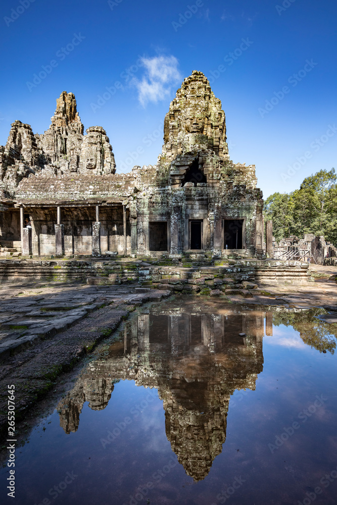 Relections of the towers and beautiful face sculptures at the famous Bayon temple in the Angkor Thom temple complex, Siem Reap, Cambodia Relections of the towers and beautiful face sculptures at the famous Bayon temple in the Angkor Thom temple complex, Siem Reap, Cambodia