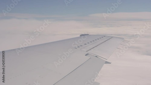 Tourism and flights. The wing of the plane against the background of the sky. View of the passenger through the eluminator. Background photo