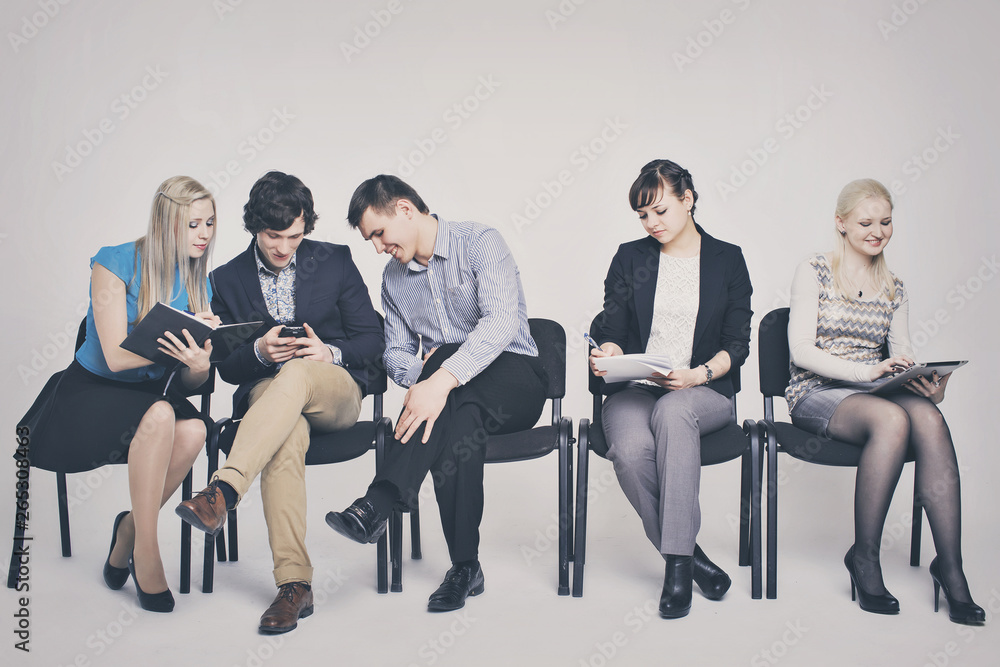 business people waiting in queue sitting in row holding smartphones and cvs, human resources, employment and hiring concept business people waiting in queue sitting in row holding smartphones and cvs, human resources, employment and hiring concept