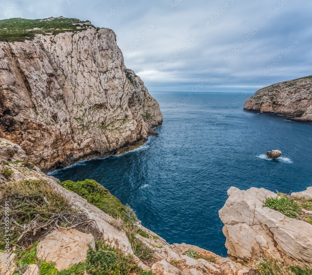 Fototapeta premium Capo Caccia, a rocky outcrop set in a protected ecosystem near the town of Alghero, Sardinia, Italy. featuring. Scenic hiking routes, diving sites & caverns with archaeological remains