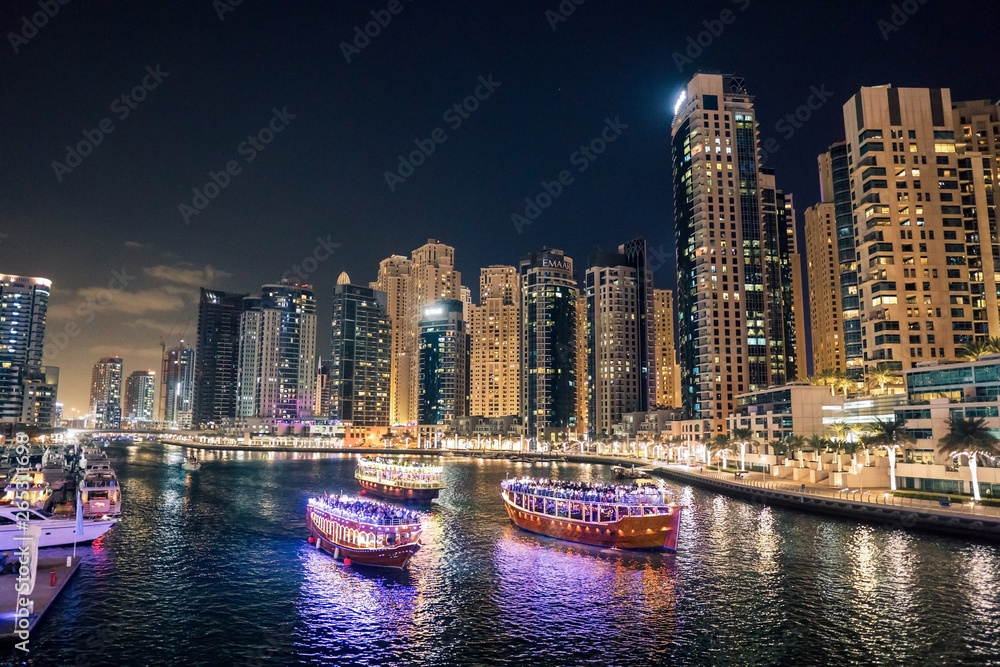 Fototapeta premium Dubai at night. Dubai marina, skylines Dubai Marina. Skyscrapers and Mosque of Dubai Marina in the evening. Ships and boats.