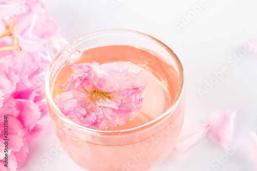Sakura tea. Closeup of cherry blossom herb tea on white