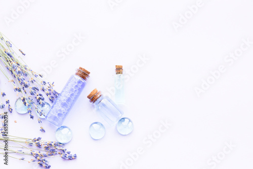 Spa and wellness setting with lavender flowers, sea salt, oil in a bottle, aroma candle on wooden white background