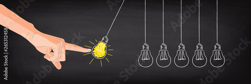 Hand stoßt Pendel - Idee Konzept auf Kreidetafel