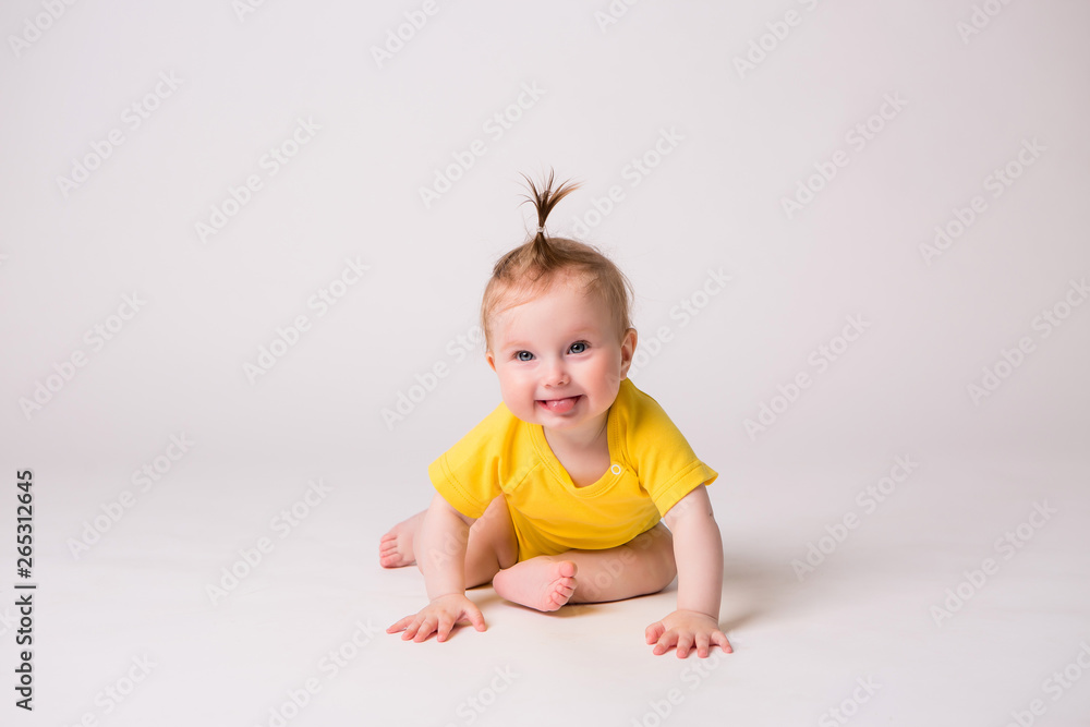 healthy baby is 6 months, baby girl smiling in a yellow bodysuit on a white background healthy baby is 6 months, baby girl smiling in a yellow bodysuit on a white background