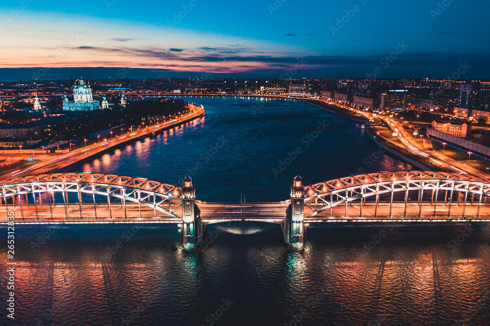 Beautiful evening scene with the famous Tower Bridge of St.Petersburg illuminated and reflected in Neva river