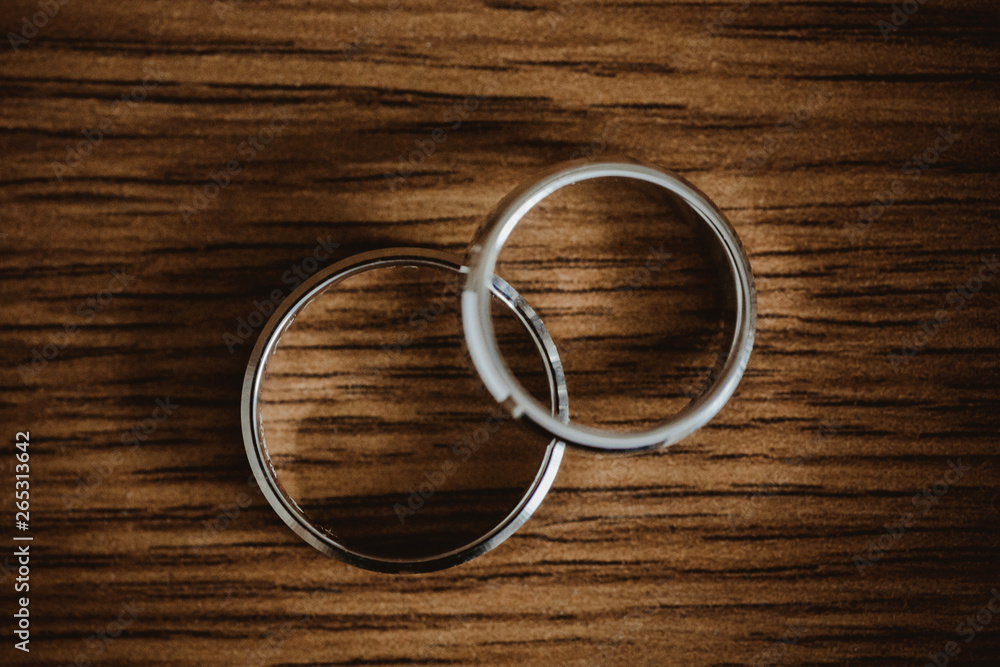 Two white gold wedding rings on wooden table. Two white gold wedding rings on wooden table.