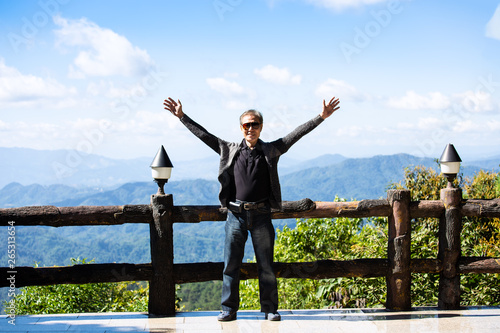 Asian old man happy ,open hand with fresh air and relax time feeling freedom on mountain background