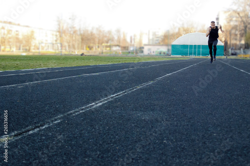 one caucasian male is doing a sprint start. running on the rubber track. Track and field runner in sport uniform. energetic physical activities. outdoor exercise  healthy lifestyle