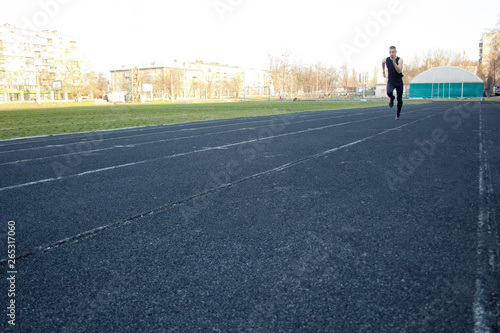 one caucasian male is doing a sprint start. running on the rubber track. Track and field runner in sport uniform. energetic physical activities. outdoor exercise  healthy lifestyle