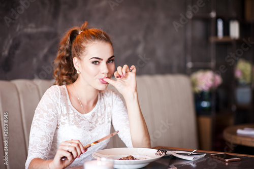 Cute woman eating tasty food in cafe closeup.