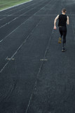 caucasian man doing a sprint start. running on the stadium on a track. Track and field runner in sport uniform. energetic physical activities. outdoor exercise, healthy lifestyle. vertical top view