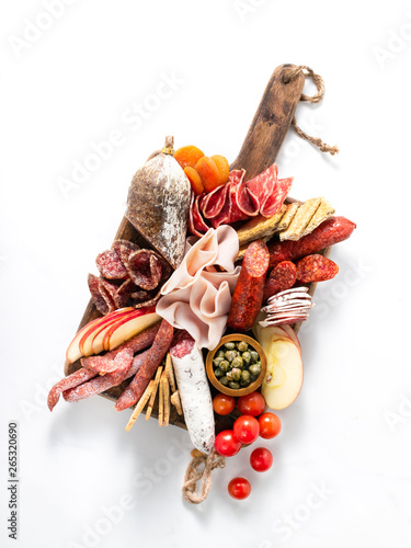 Cold meat plate, charcuterie on white background with copy space. Traditional Spanish tapas selection - chorizo, salchichon, jamon serrano, lomo, salami. photo