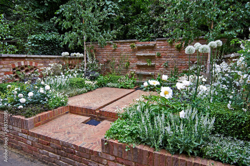 A herringbone brick courtyard garden with an all white planting