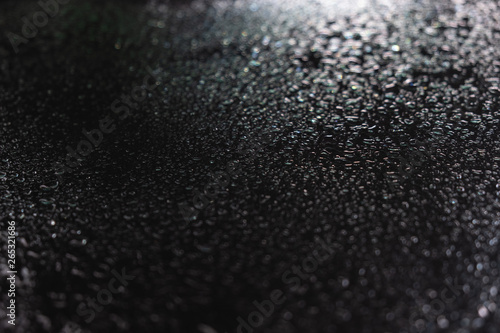 Drops of water on the black glass. Side view