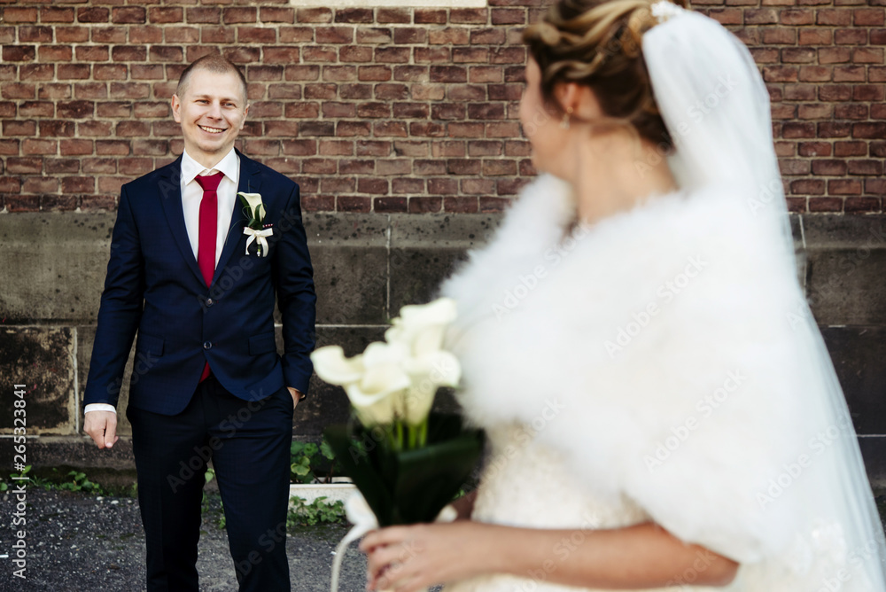 happy gorgeous blonde bride and stylish handsome groom with true emotions on background of old city wall happy gorgeous blonde bride and stylish handsome groom with true emotions on background of old city wall